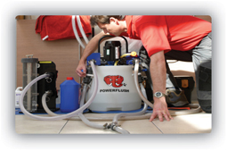 Engineer powerflushing a central heating system